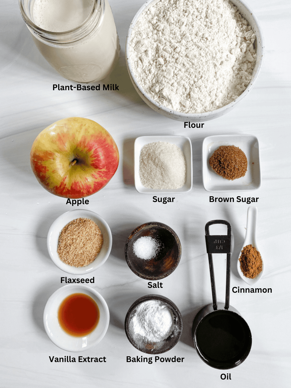 Apple Cinnamon Waffles Ingredients spread out on a white marble surface.