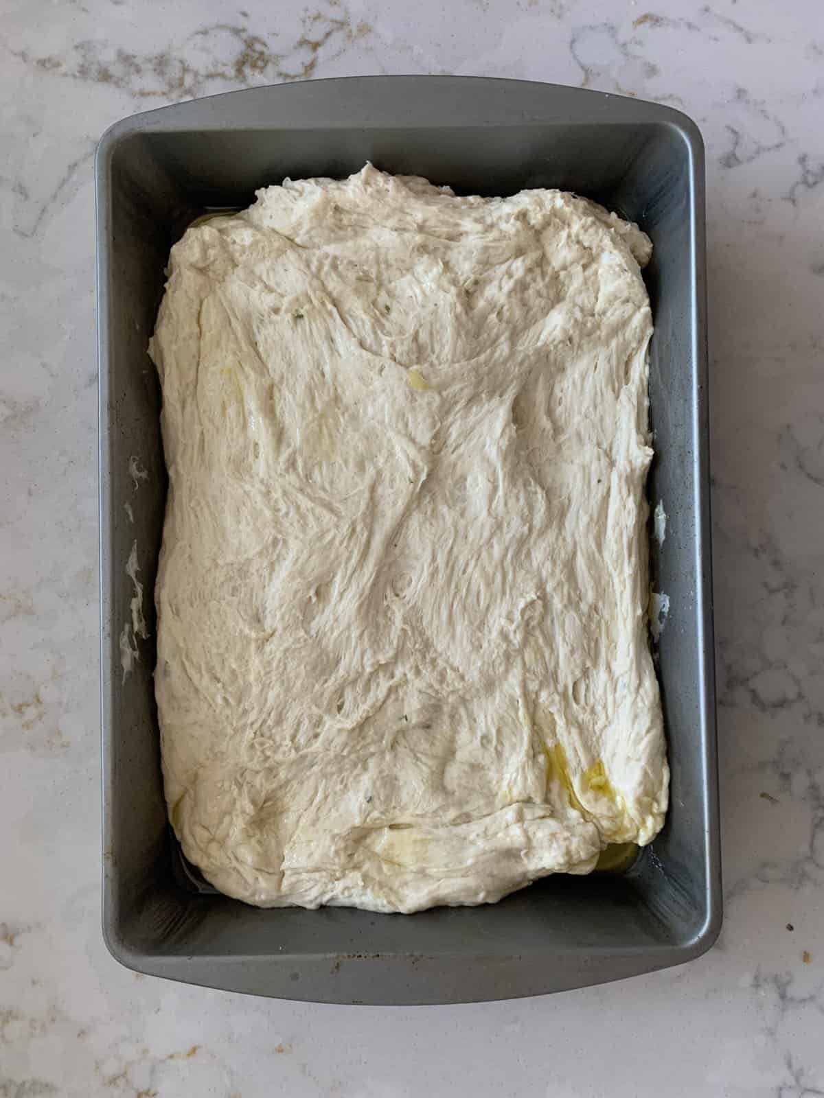 process of formed and shaped Vegan Focaccia dough in baking tray