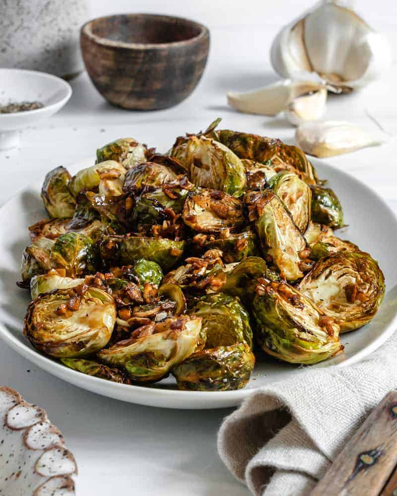 finished Crispy Air Fryer Brussels Sprouts plated on a white dish against a white background 