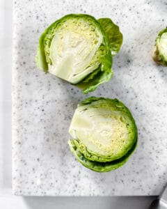 sliced brussels sprouts on a light cutting board
