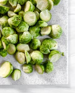 sliced brussels sprouts on a white cutting board