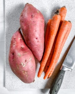 Yams and Carrots against a white surface