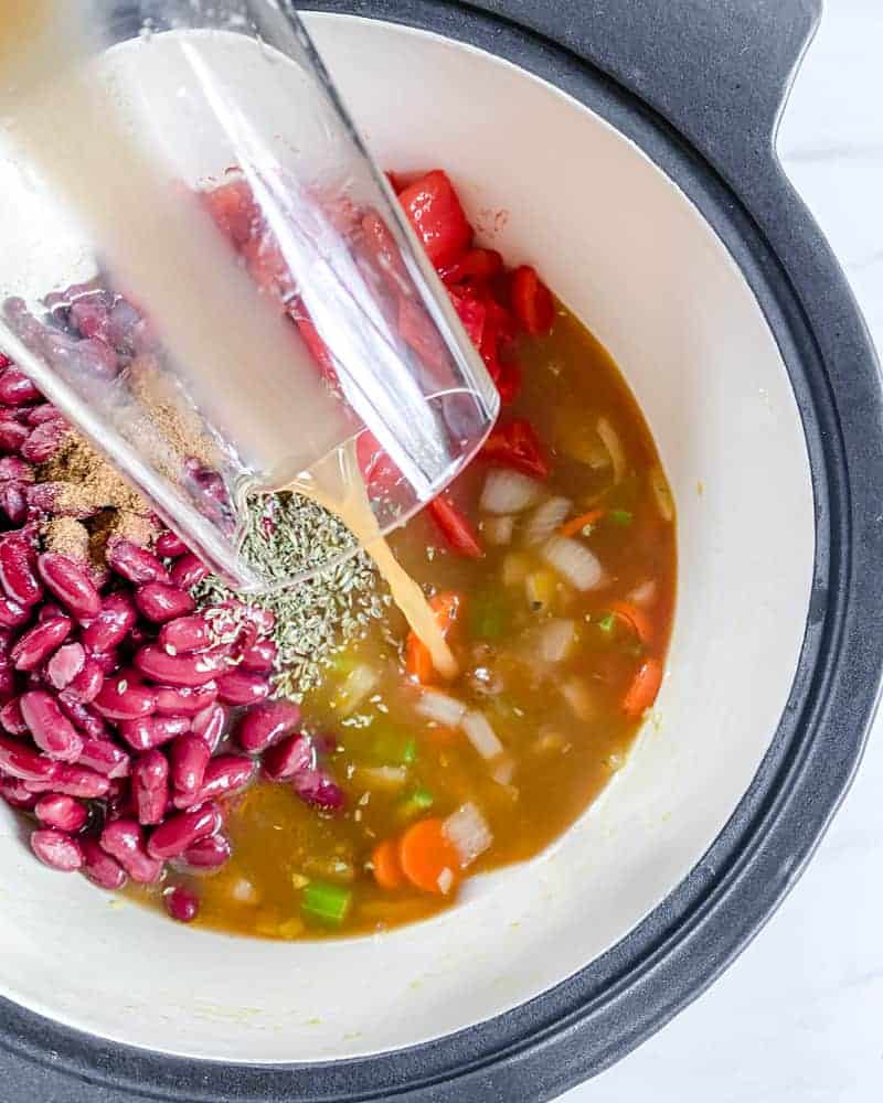 process of cooking Vegan Minestrone Soup in pot with adding wet ingredients