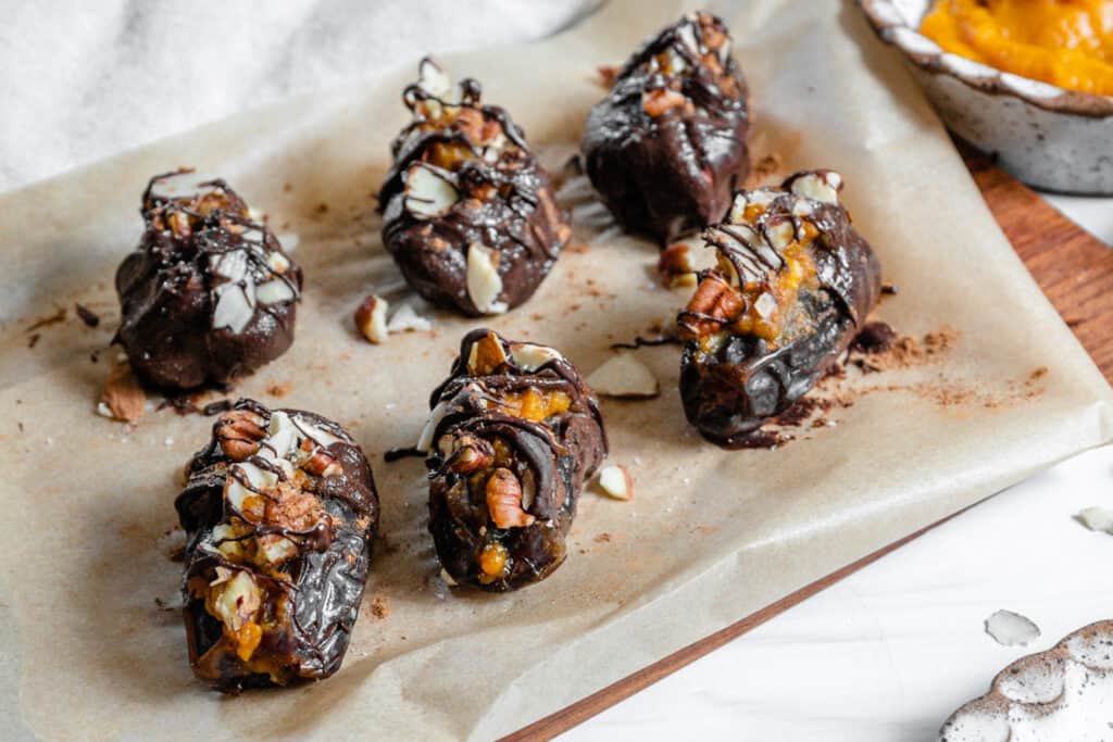 several finished chocolate covered dates on parchment paper