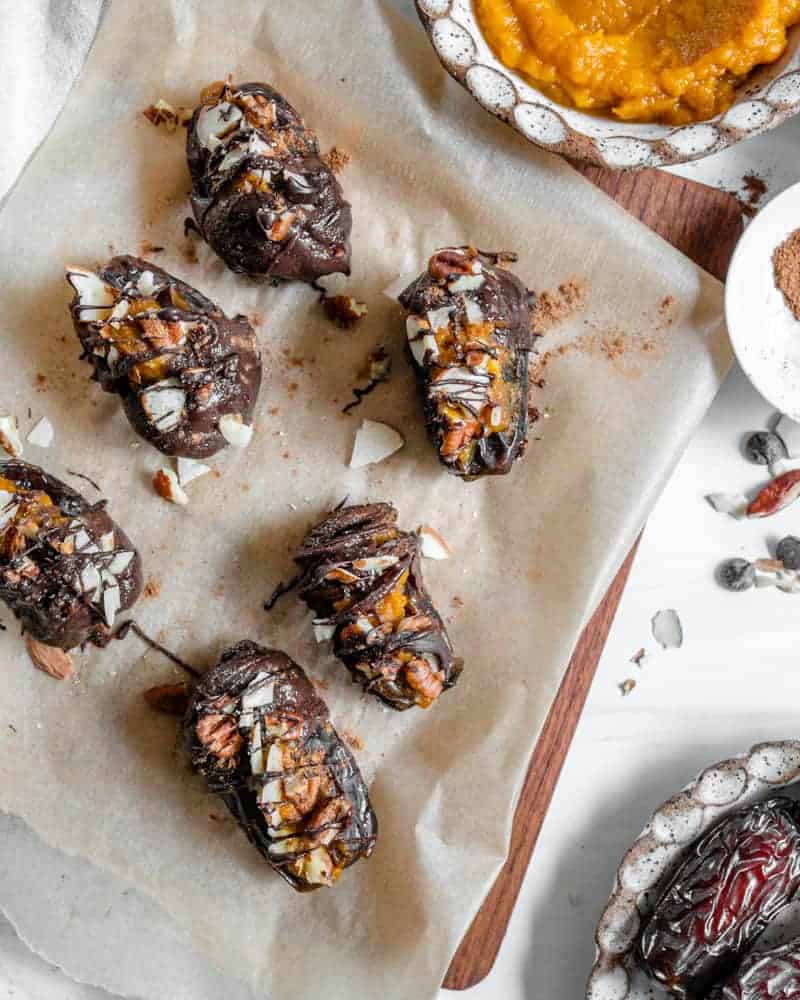 6 finished Pumpkin Stuffed Dates on parchment paper 