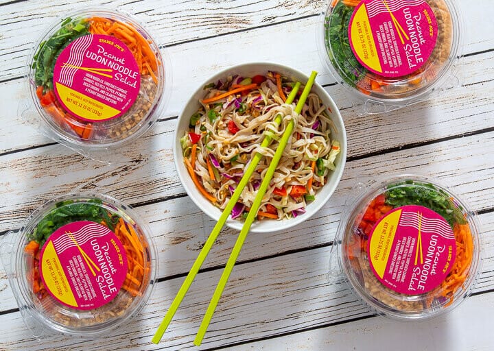 peanut udon salad packaging with a white bowl of the noodles against a gray/white background