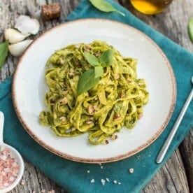 finished walnut pesto on a white plate against a blue towel and dark background