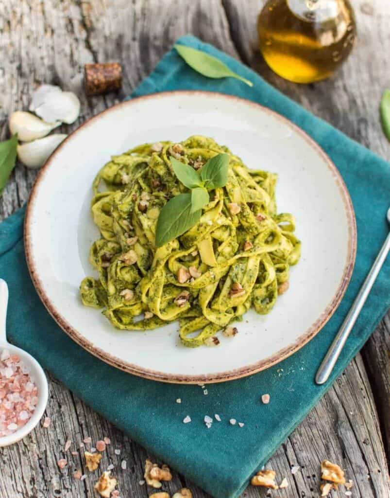 finished walnut pesto on a white plate against a blue towel and dark background