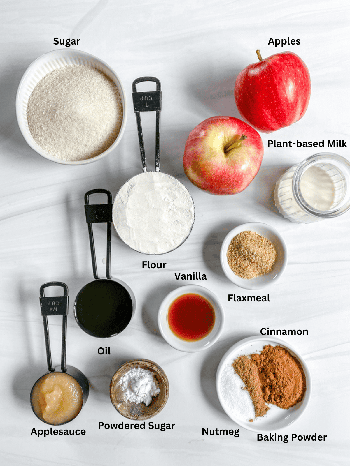 ingredients for apple cake measured out on a white surface