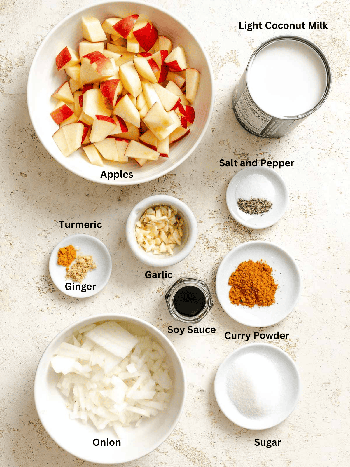 Ingredients for Creamy Apple Curry measured out on a white surface.