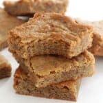finished gluten free maple blondies stacked on each other against a white background