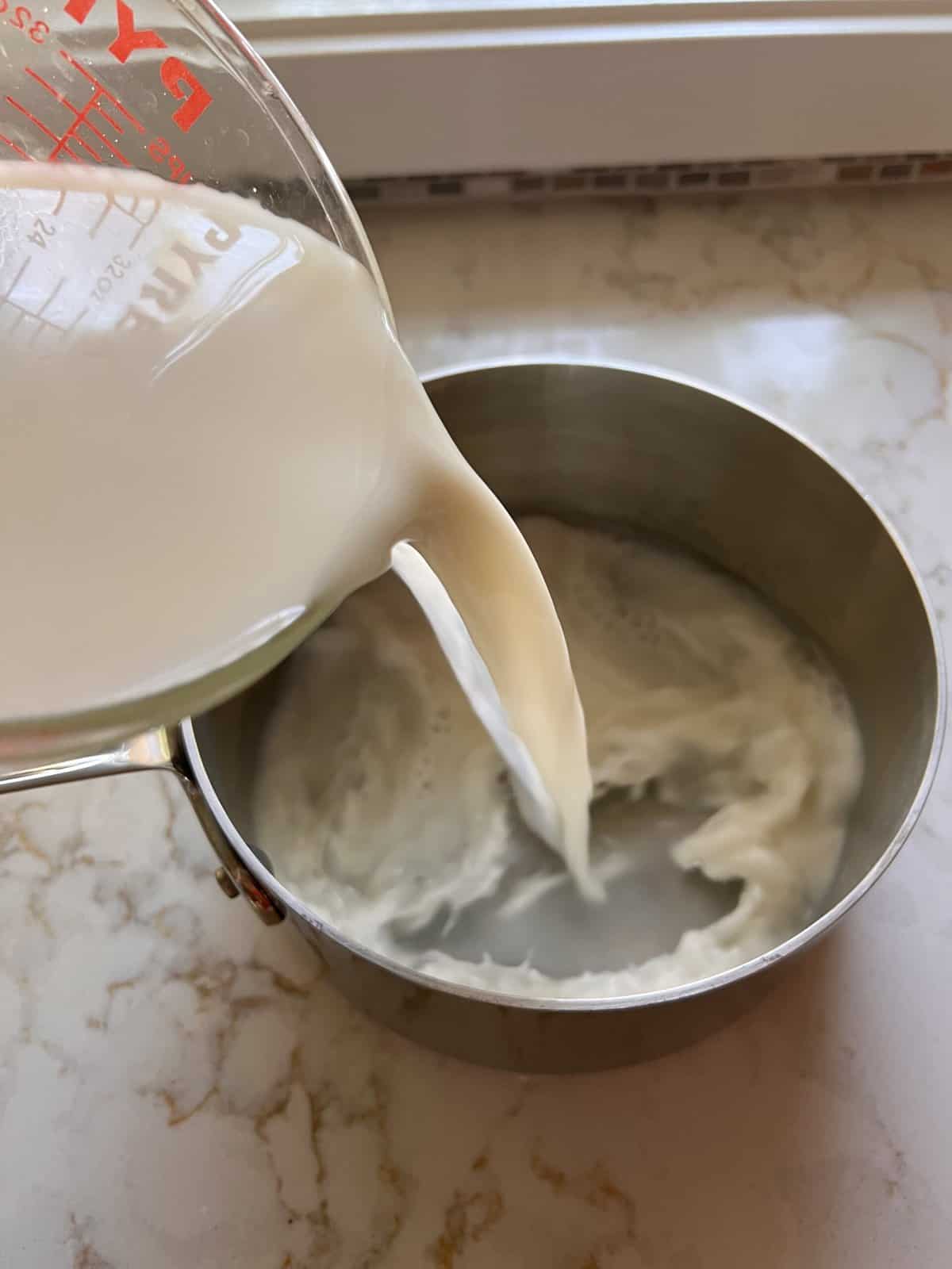 process of pouring milk into pan