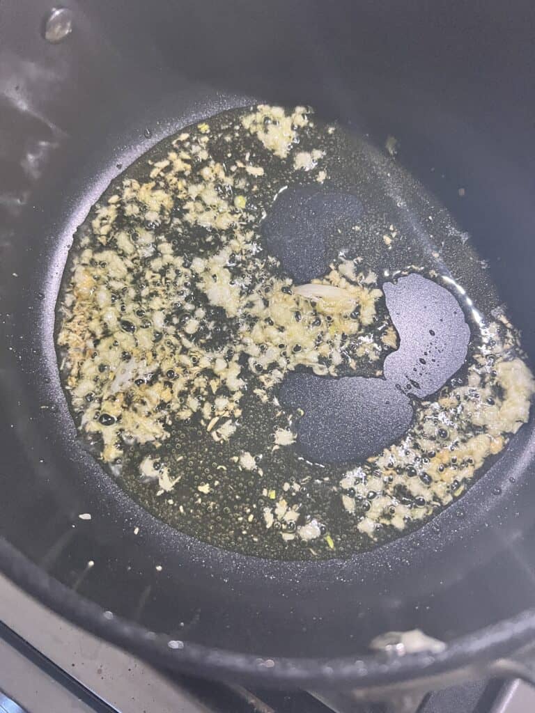 process shot showing garlic in a pan