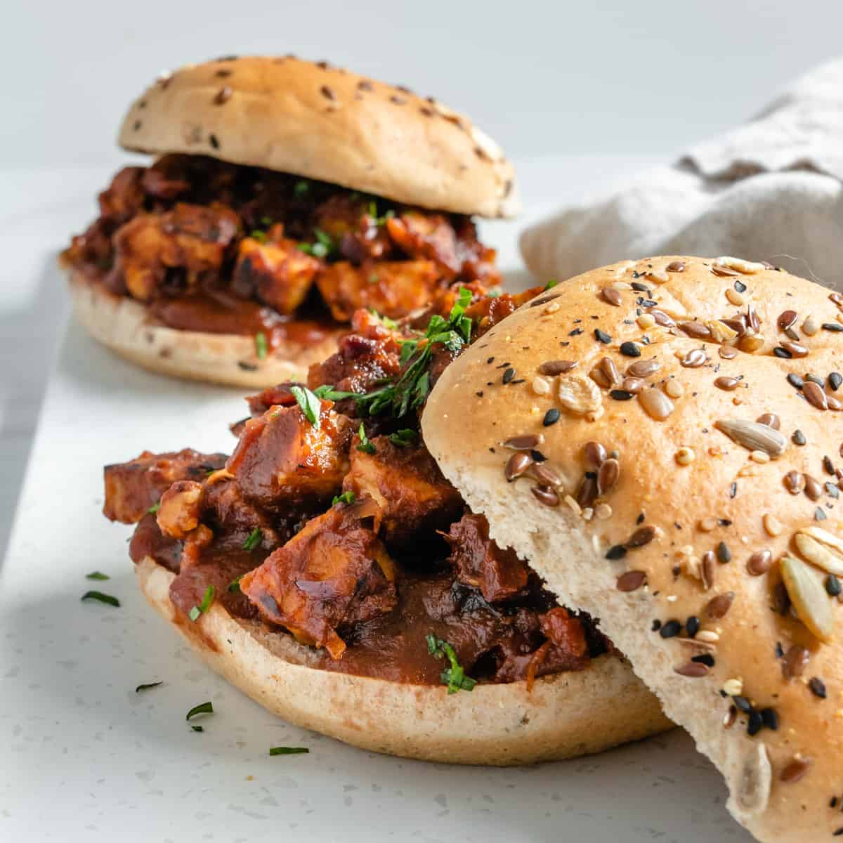 two completed BBQ Tempeh Sandwiches against a white surface