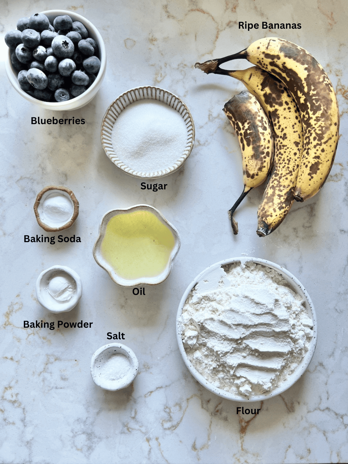 ingredients for Blueberry Banana Muffins measured out on a white surface