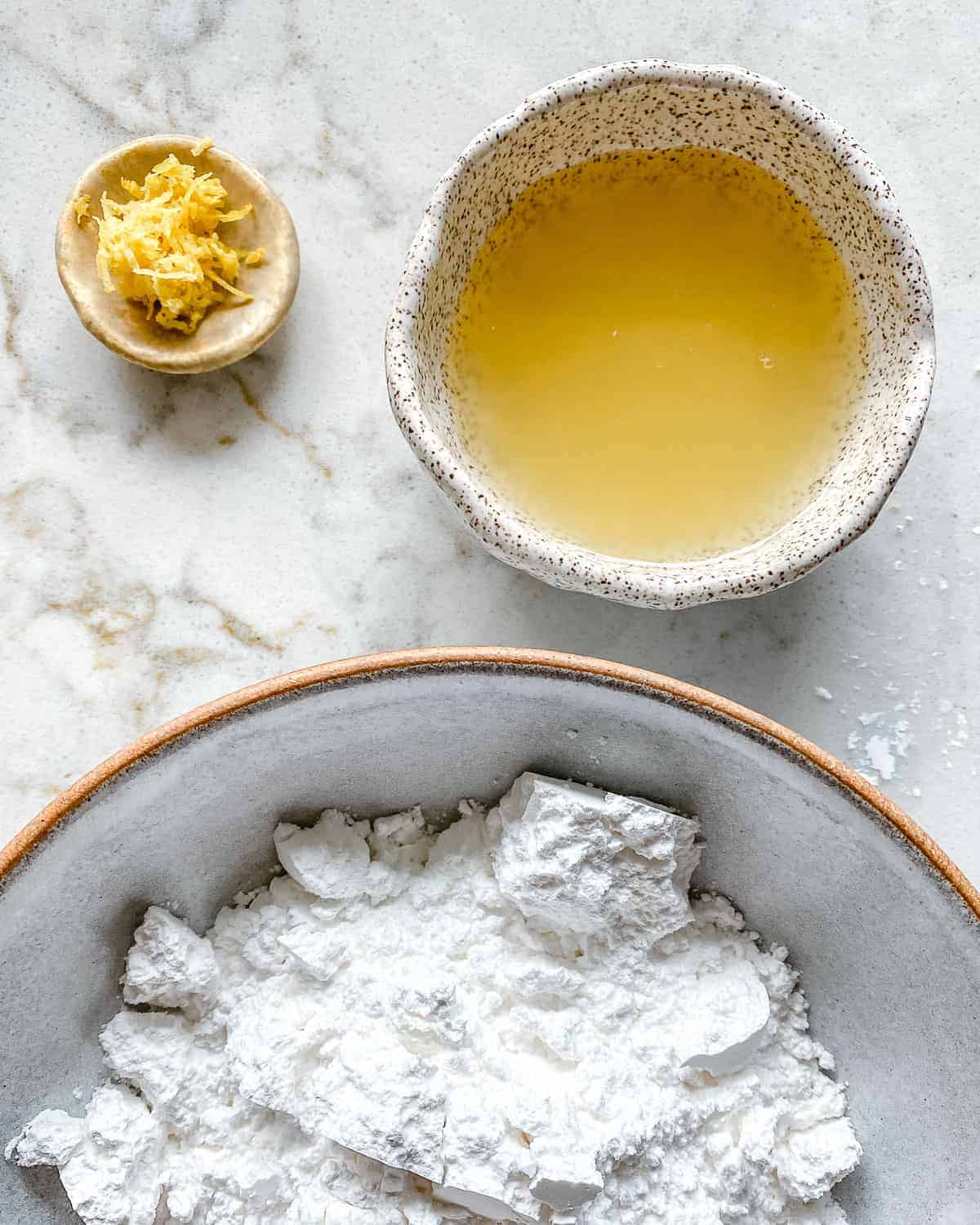 ingredients for lemon glaze measured out against white background