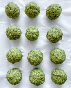 several uncooked Red Lentil Meatballs on white parchment paper