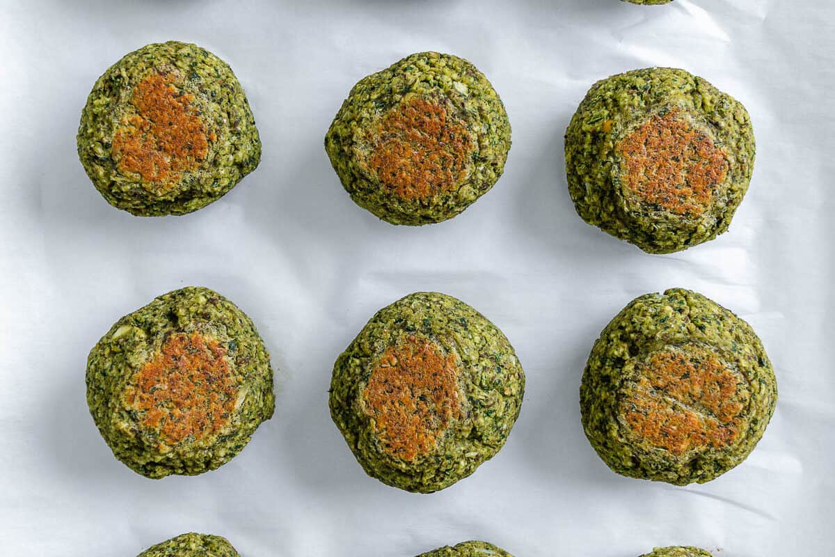 completed red lentil meatballs lined up and evenly spaced on a white surface