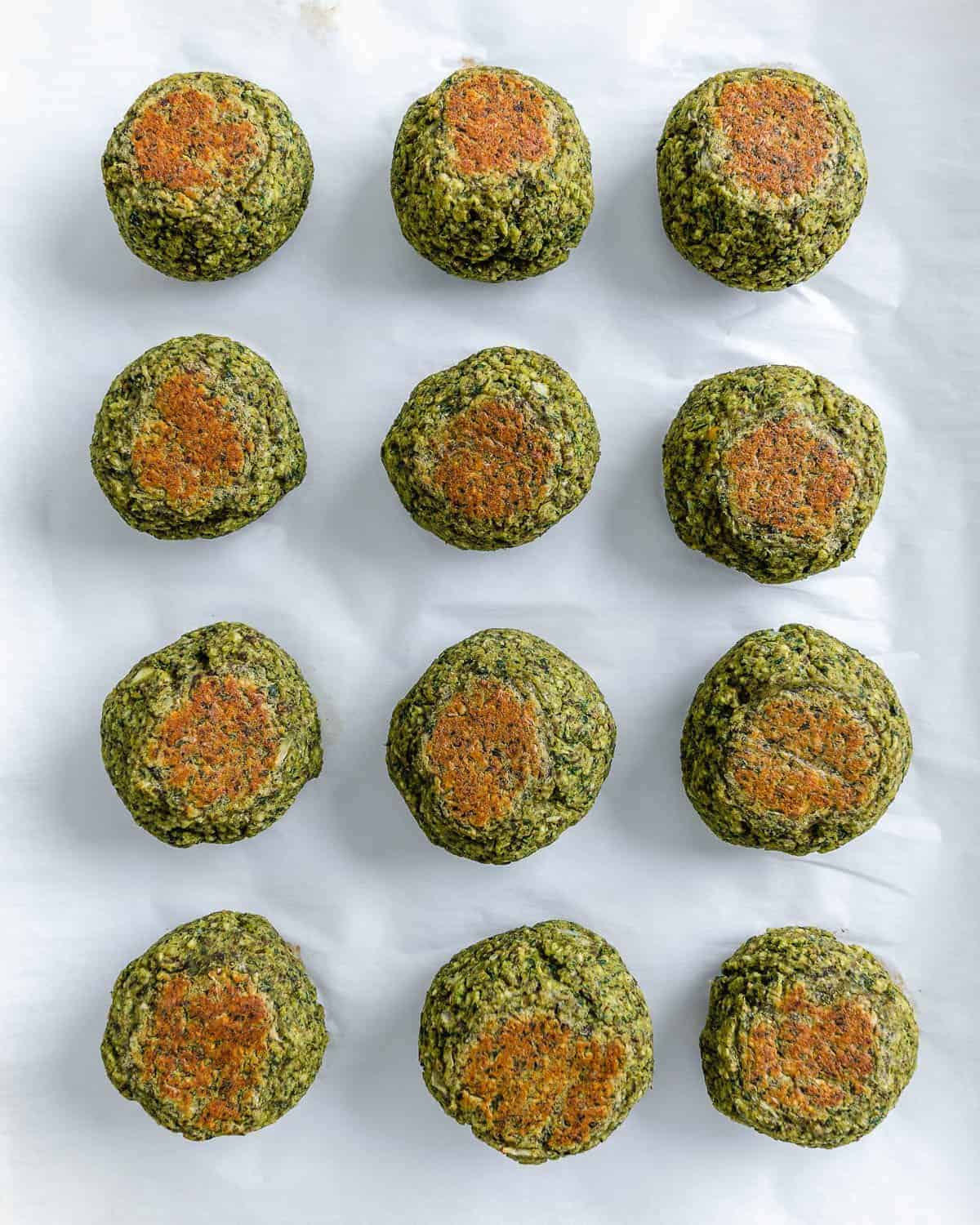 completed red lentil meatballs lined up and evenly spaced on a white surface