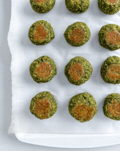 completed red lentil meatballs lined up and evenly spaced on a white surface