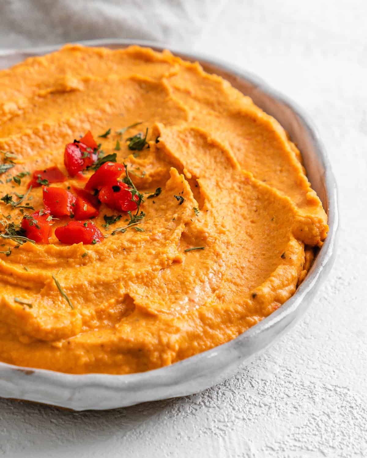 completed Smoky Roasted Red Pepper Hummus against a white background