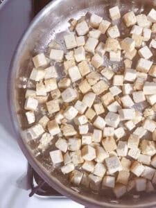 process shot showing tofu being cooked in pan