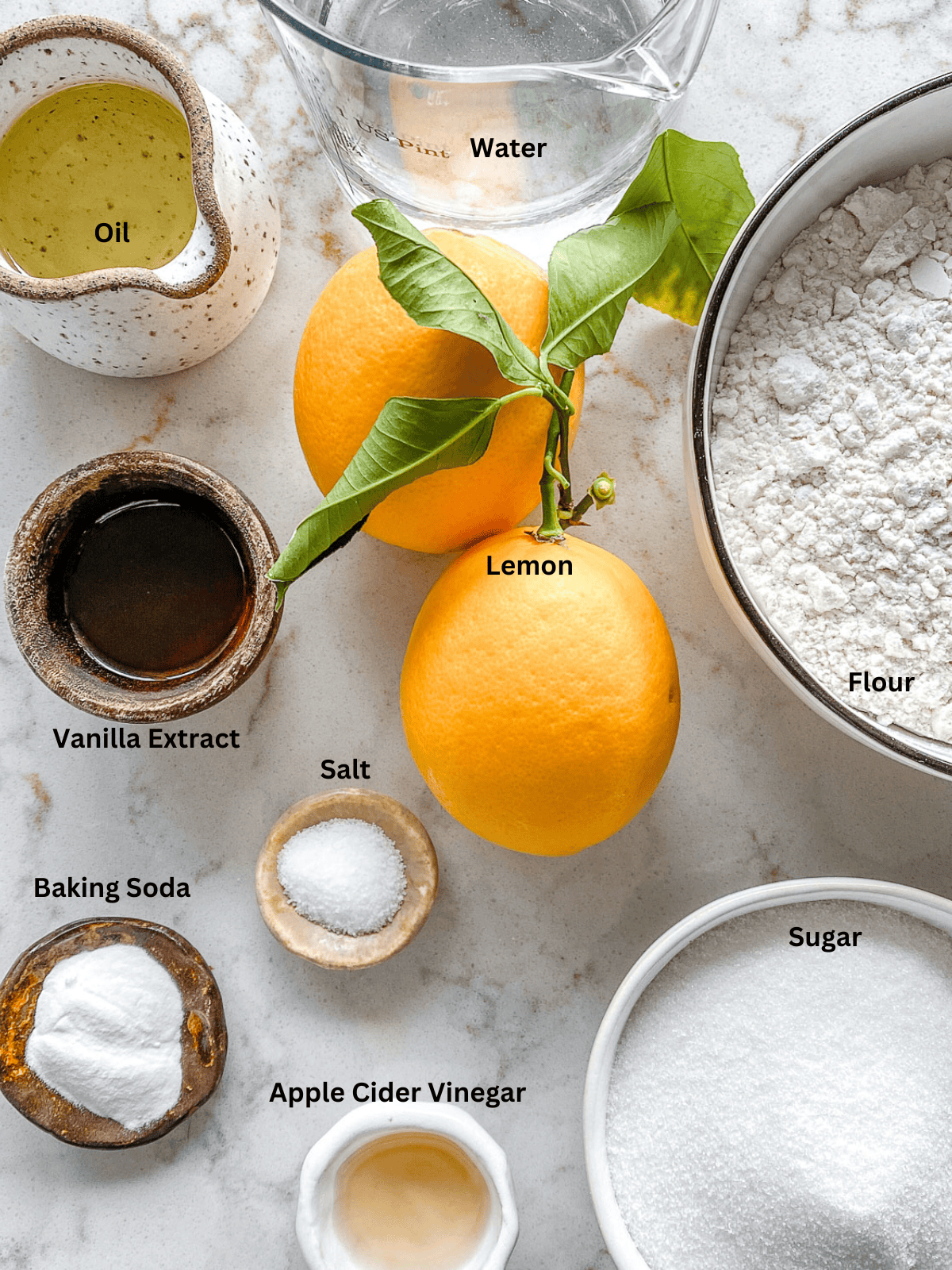 ingredients for Lemon Vanilla Cupcakes measured out on a white surface