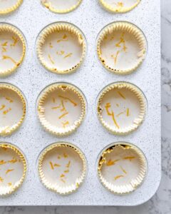 batter of lemon cupcakes in paper liners of muffin tin