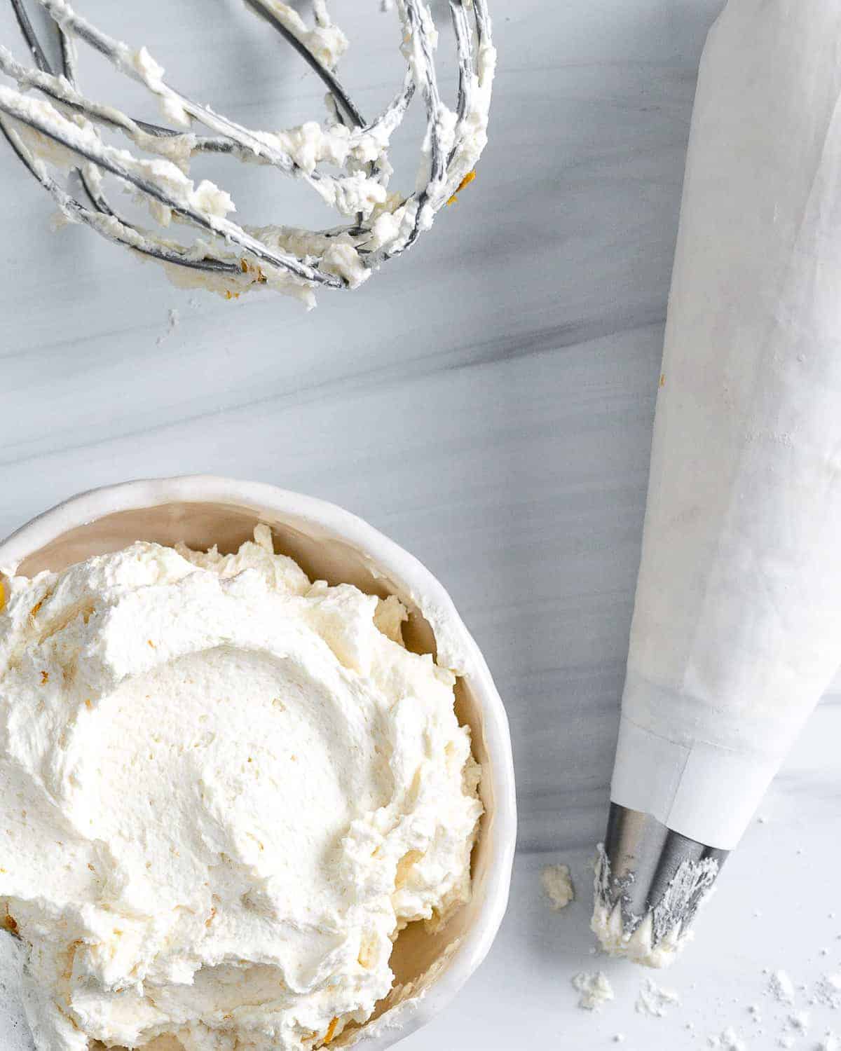 completed Lemon Buttercream Frosting in a white bowl against a white background