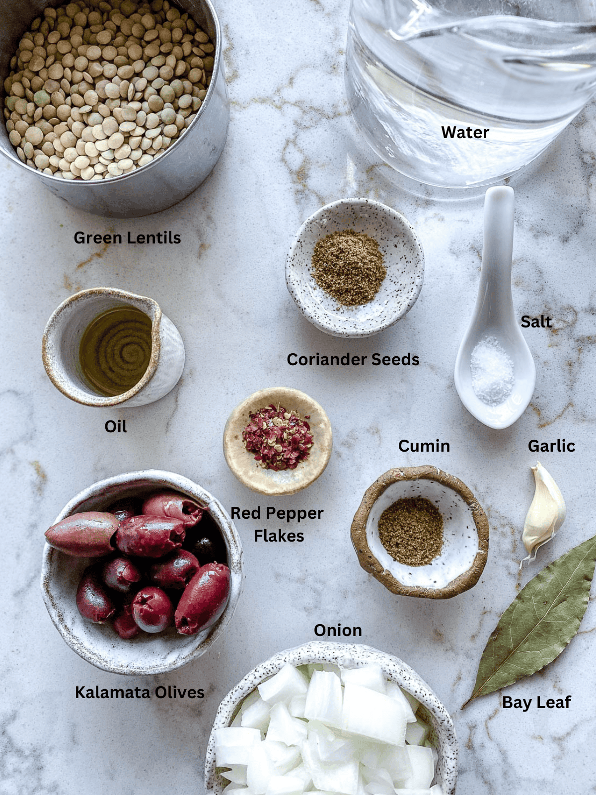 Ingredients for Spicy Lentil Kalamata Dip measured out against a white surface.