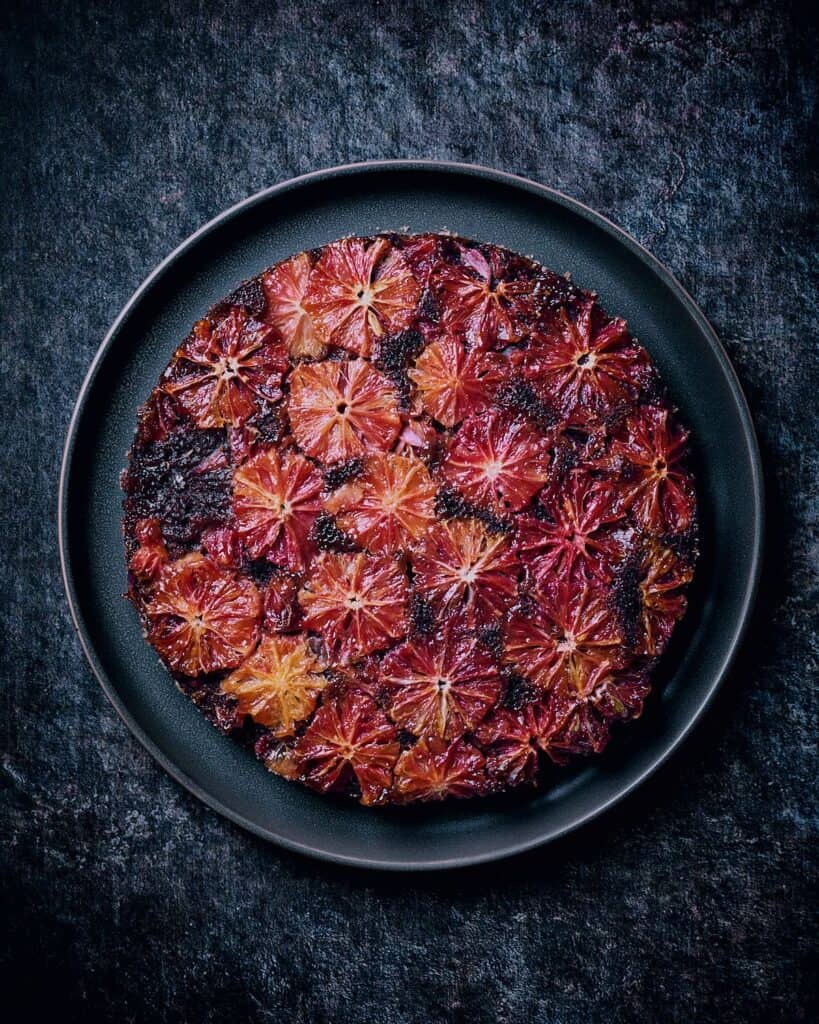 completed Chocolate Blood Orange Cake against a dark background