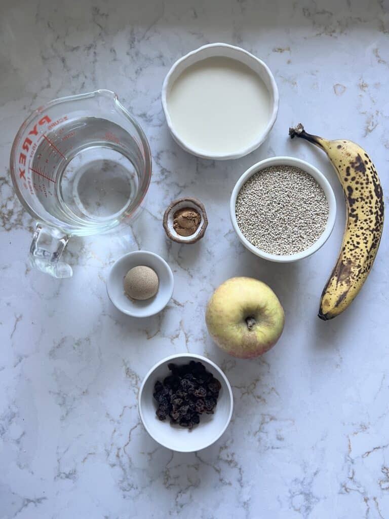 ingredients for Breakfast Quinoa Apple Bowl measured out against a white marble surface