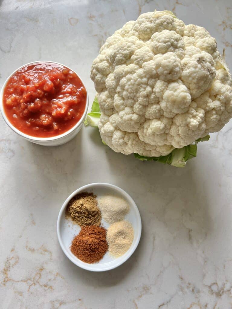 ingreidnets for spanish cauliflower rice against white marble backgrou d