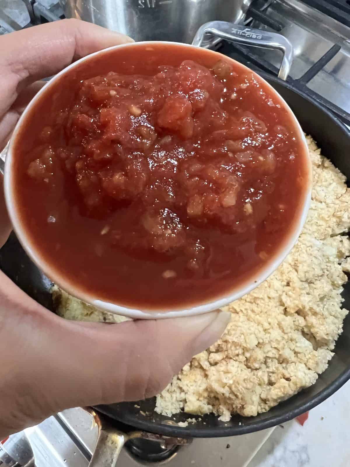 process of adding salsa to cauliflower rice