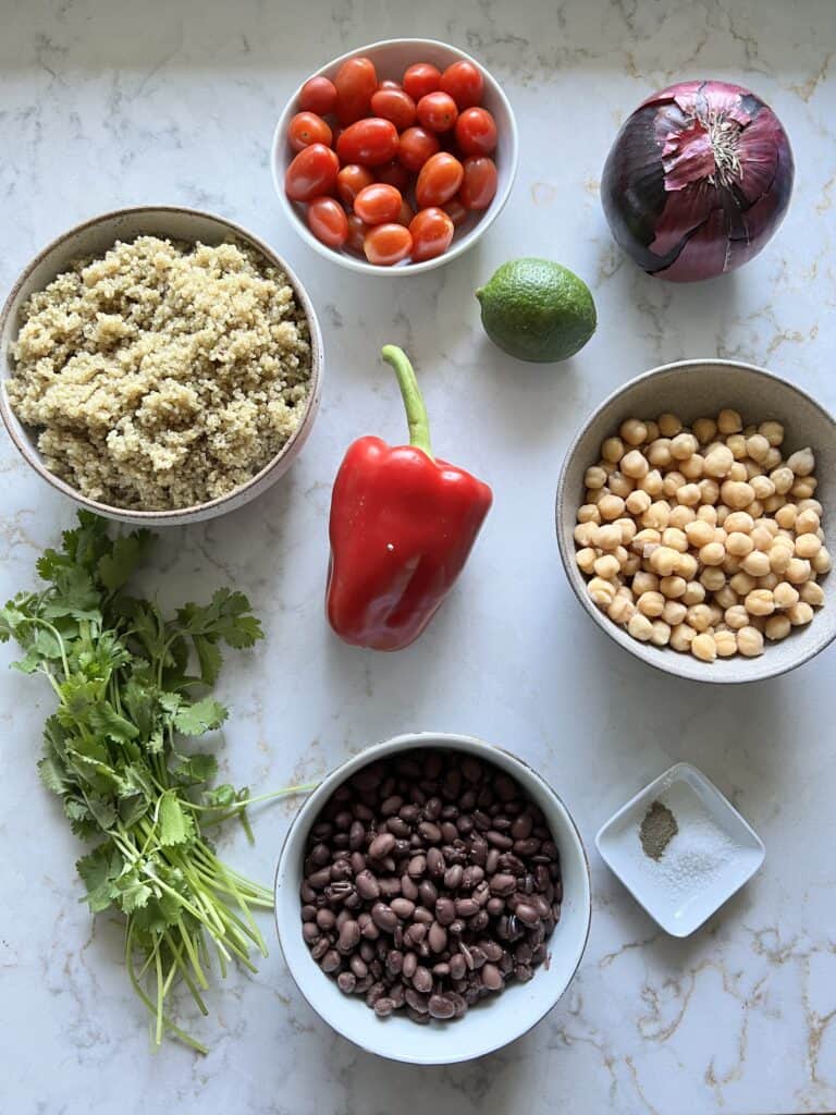 ingredients measured out for fresh quinoa salad against a white surface