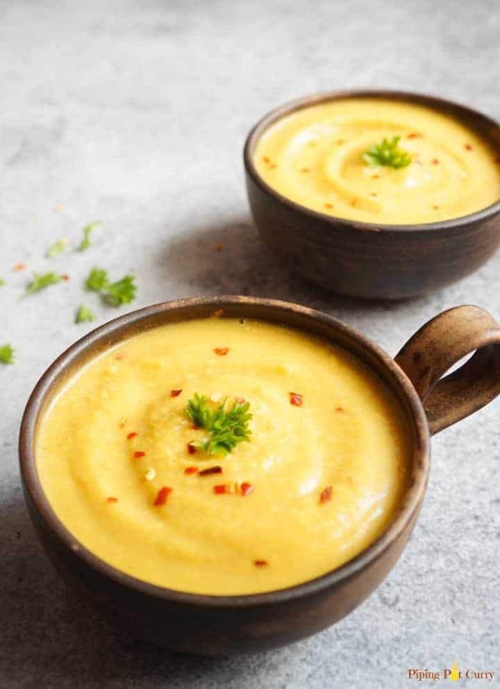 completed Vegan Instant Pot Turmeric Cauliflower Soup in two brown bowls against a light background