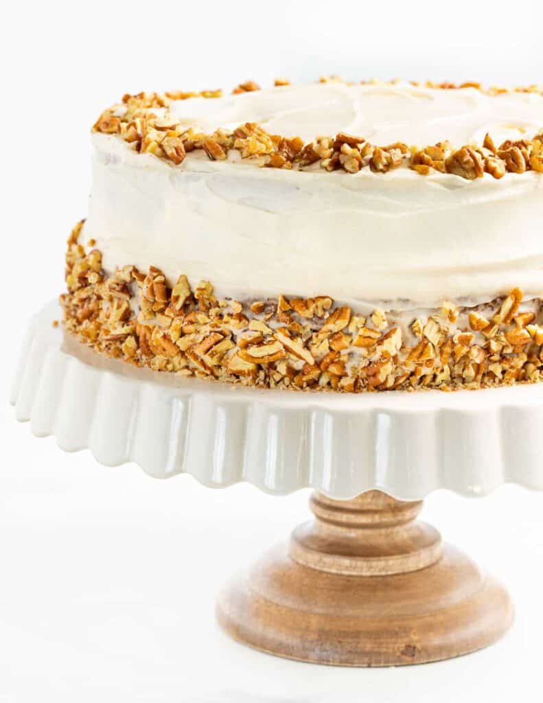 completed Vegan Hummingbird Cake on a cake platter against a white background