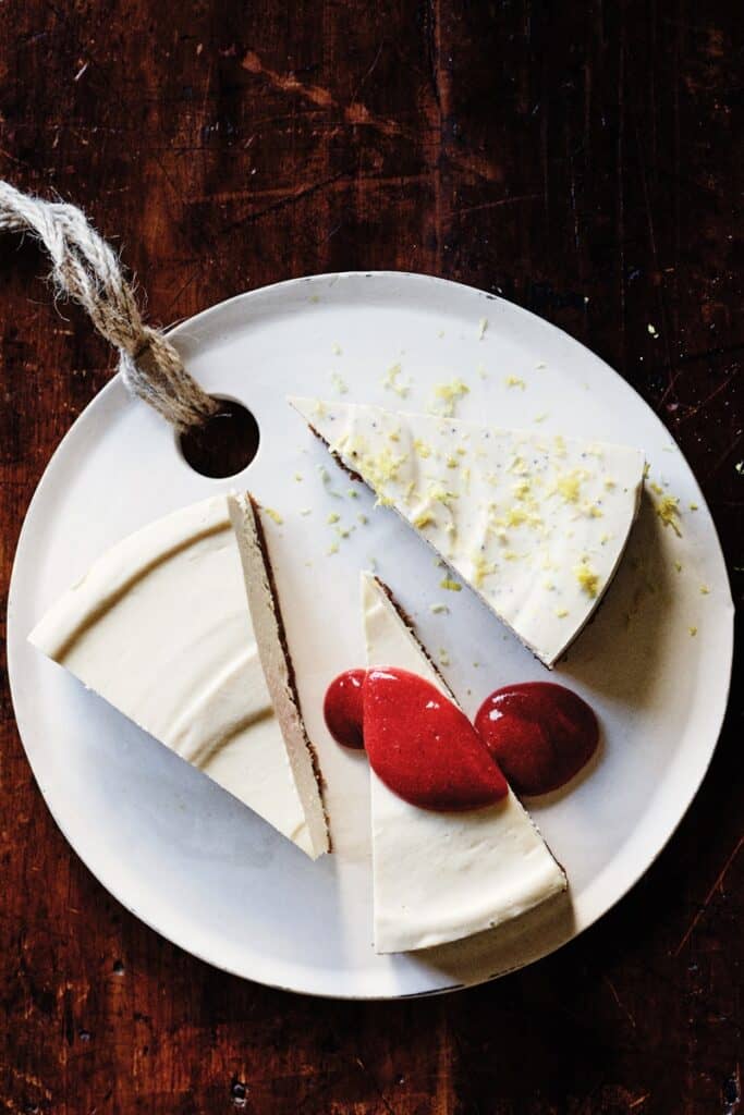 completed Classic Cheesecake with Strawberry Sauce with three slices plated on a white plate