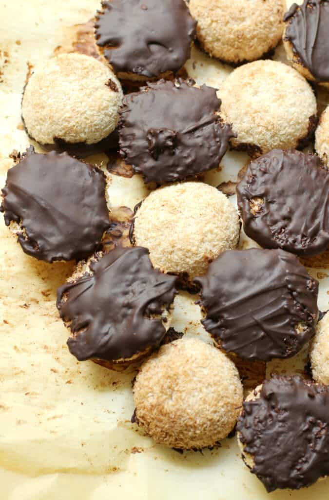 several completed Chocolate Dipped Coconut Macaroons scattered on a yellow surface