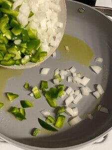 process of adding diced pepper and and onion in a pan