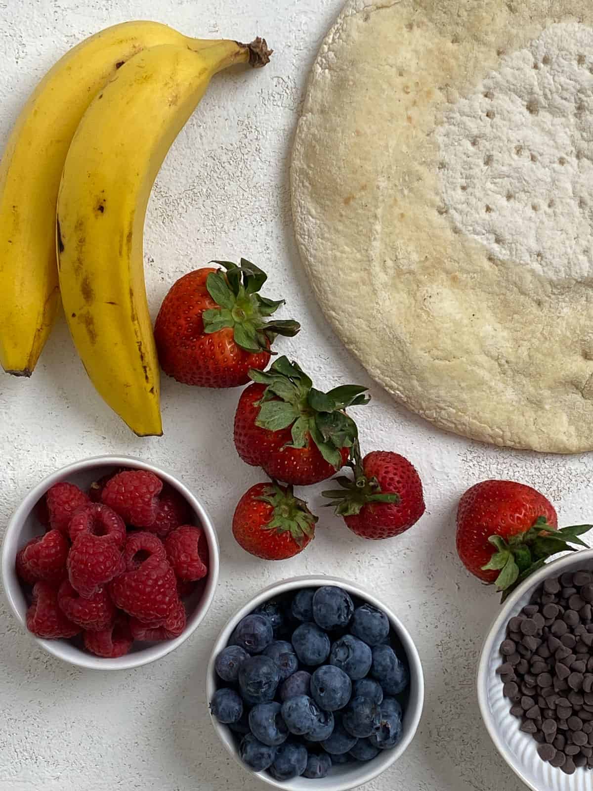 ingredients for fruit pizza against a white background