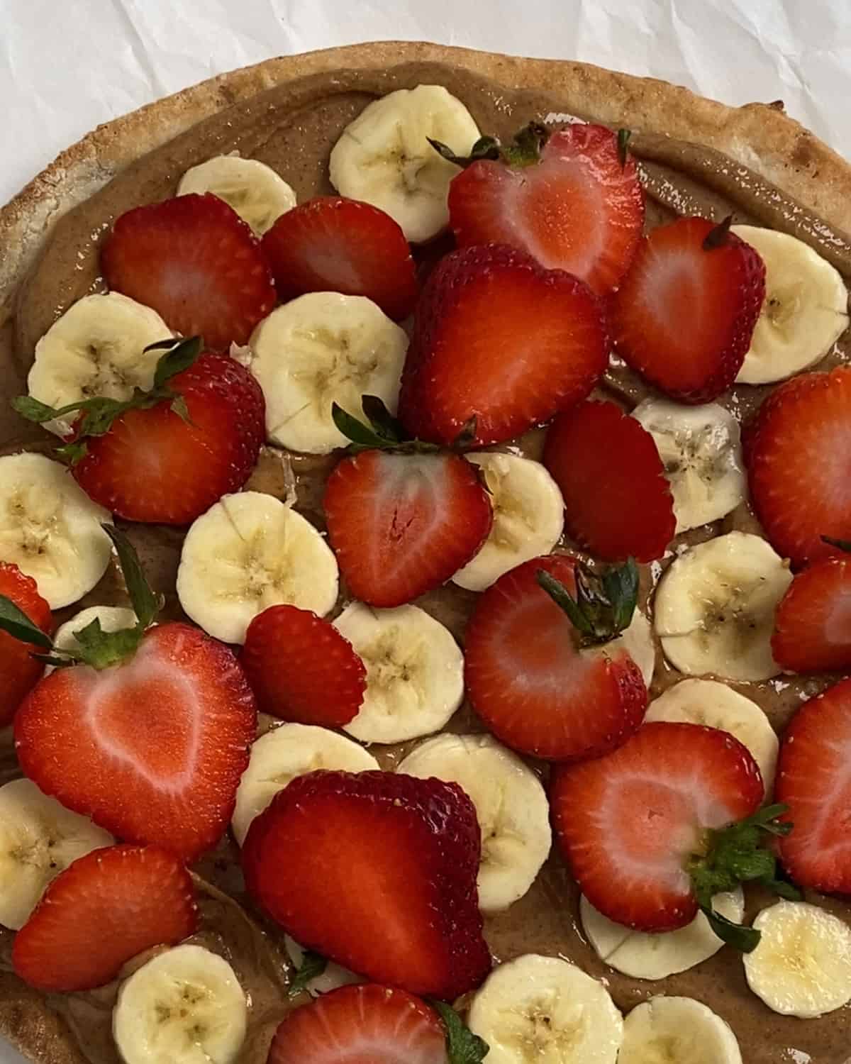 process of adding strawberries to fruit pizza