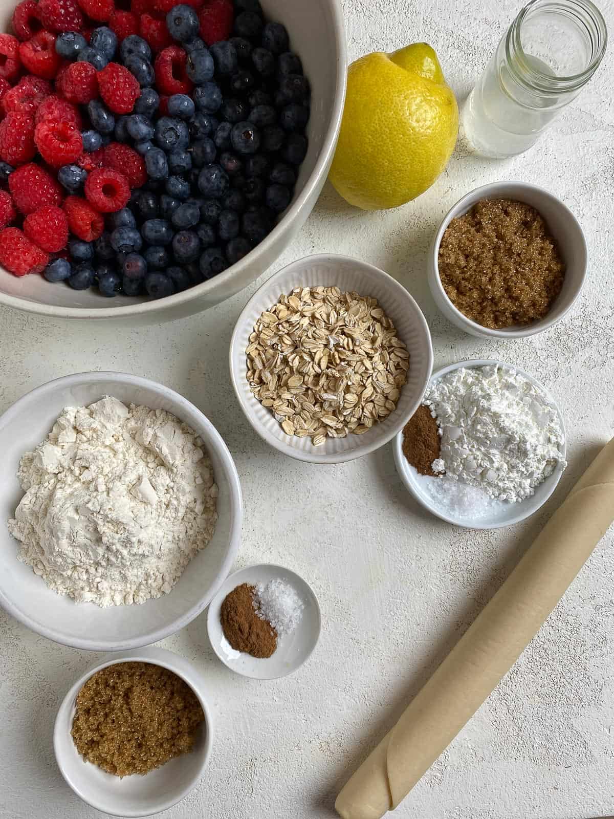 ingredients for Mixed Berry Crumb Pie measured out on a white surface