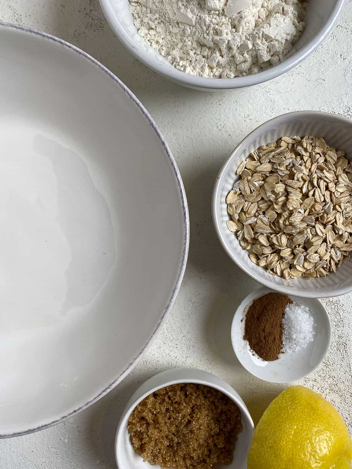 ingredients for Mixed Berry Crumb Pie measured out on a white surface alongside a bowl