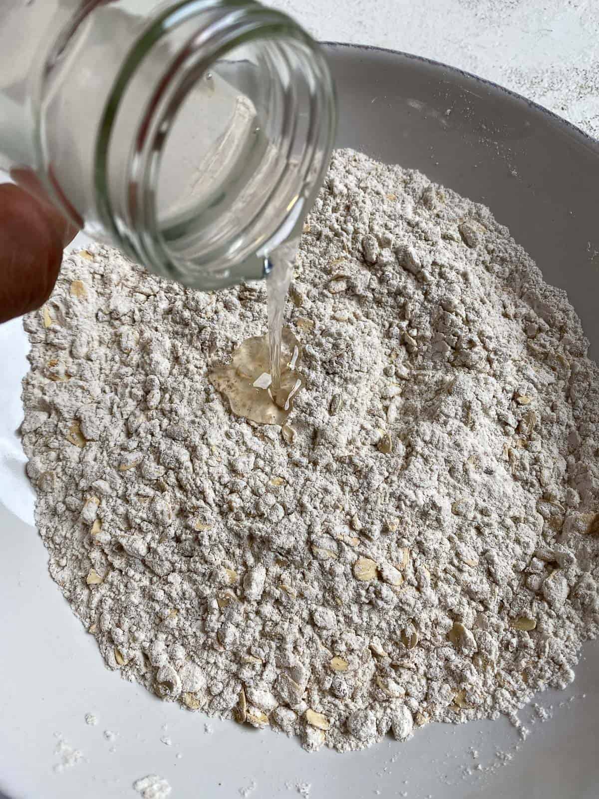 process of adding coconut oil to crumb topping mixture in bowl