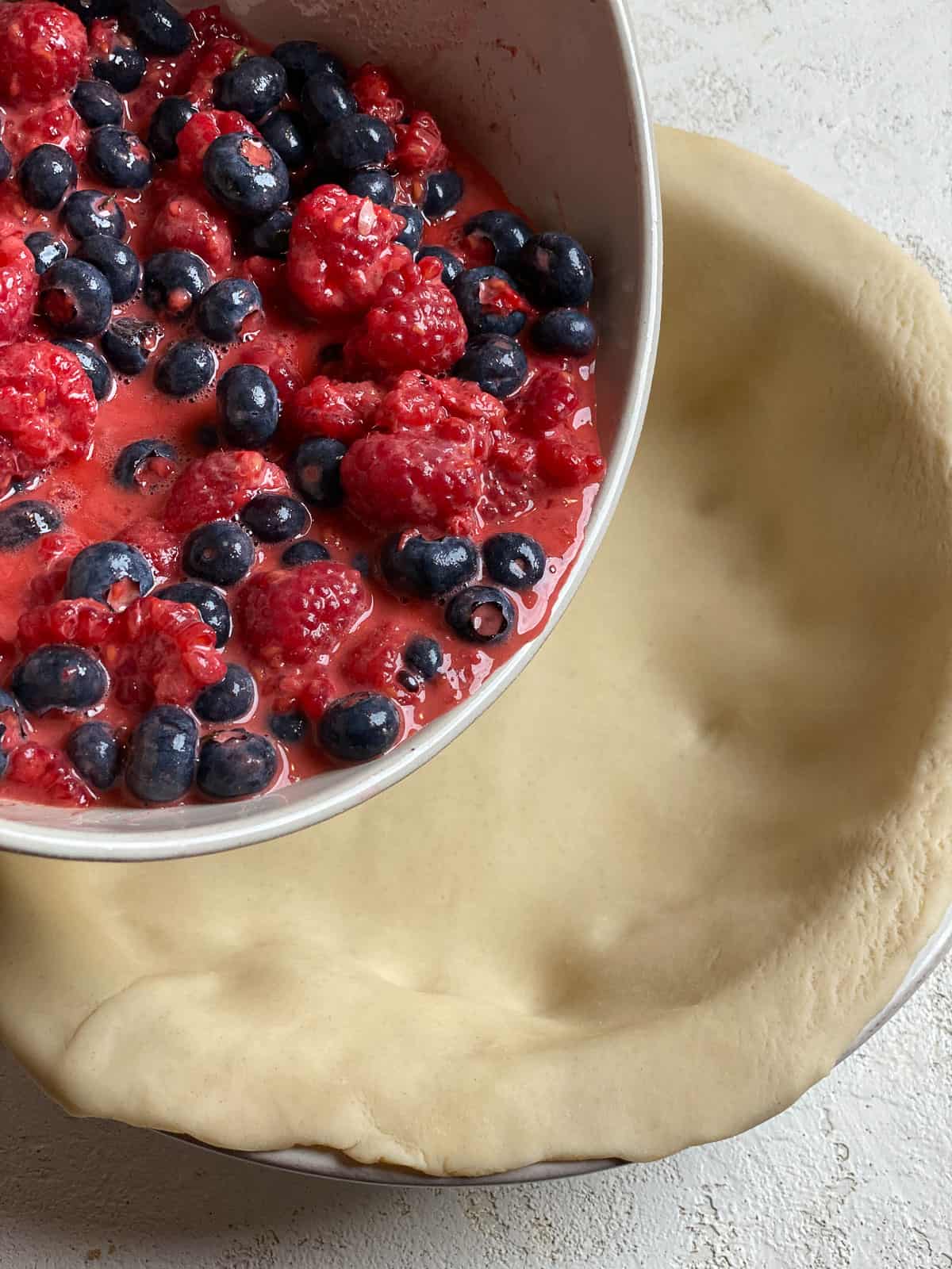 process of adding berry ingredient mixture to pie crust