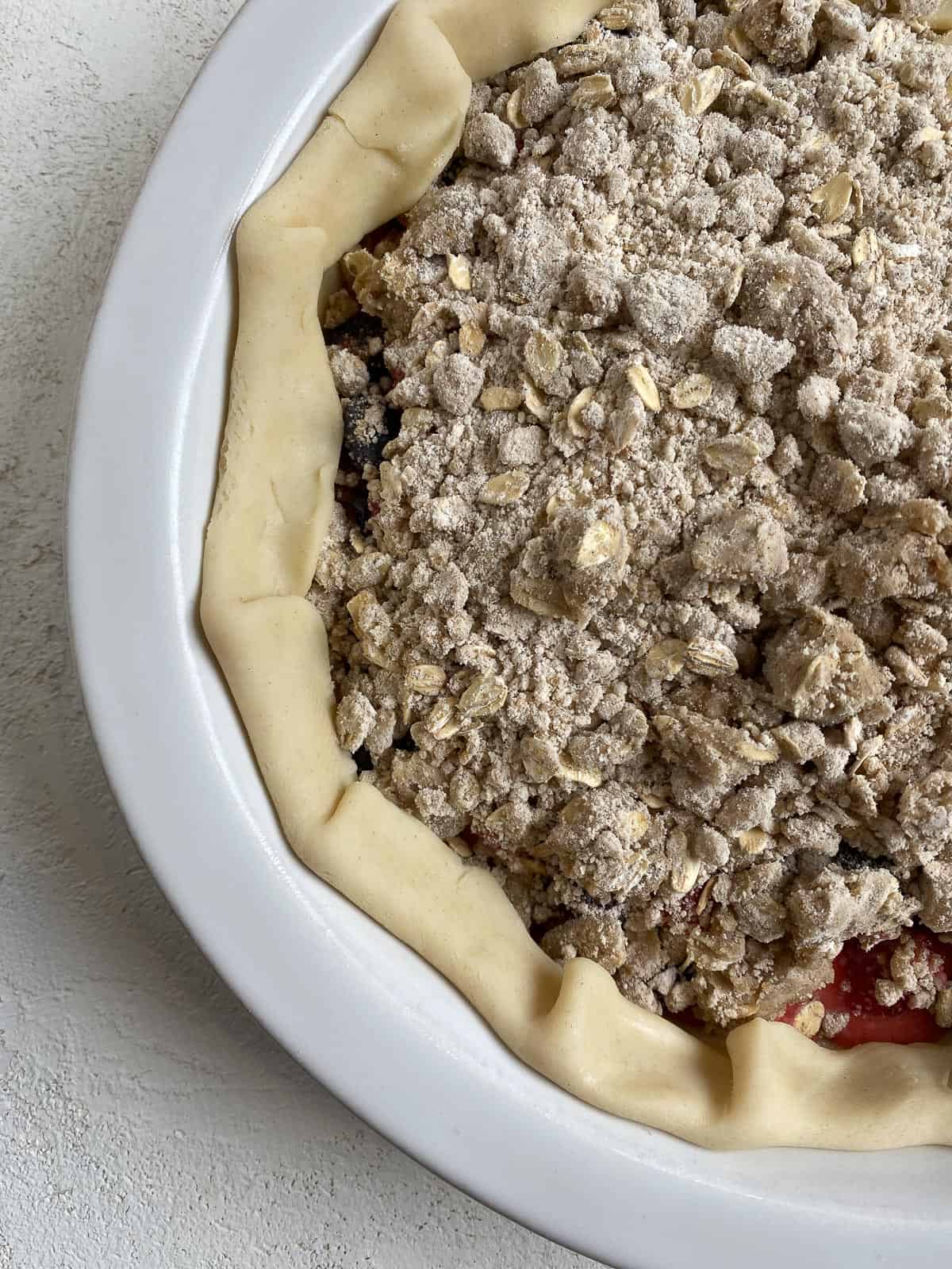 pre-baked close up of Mixed Berry Crumb Pie in pie dish