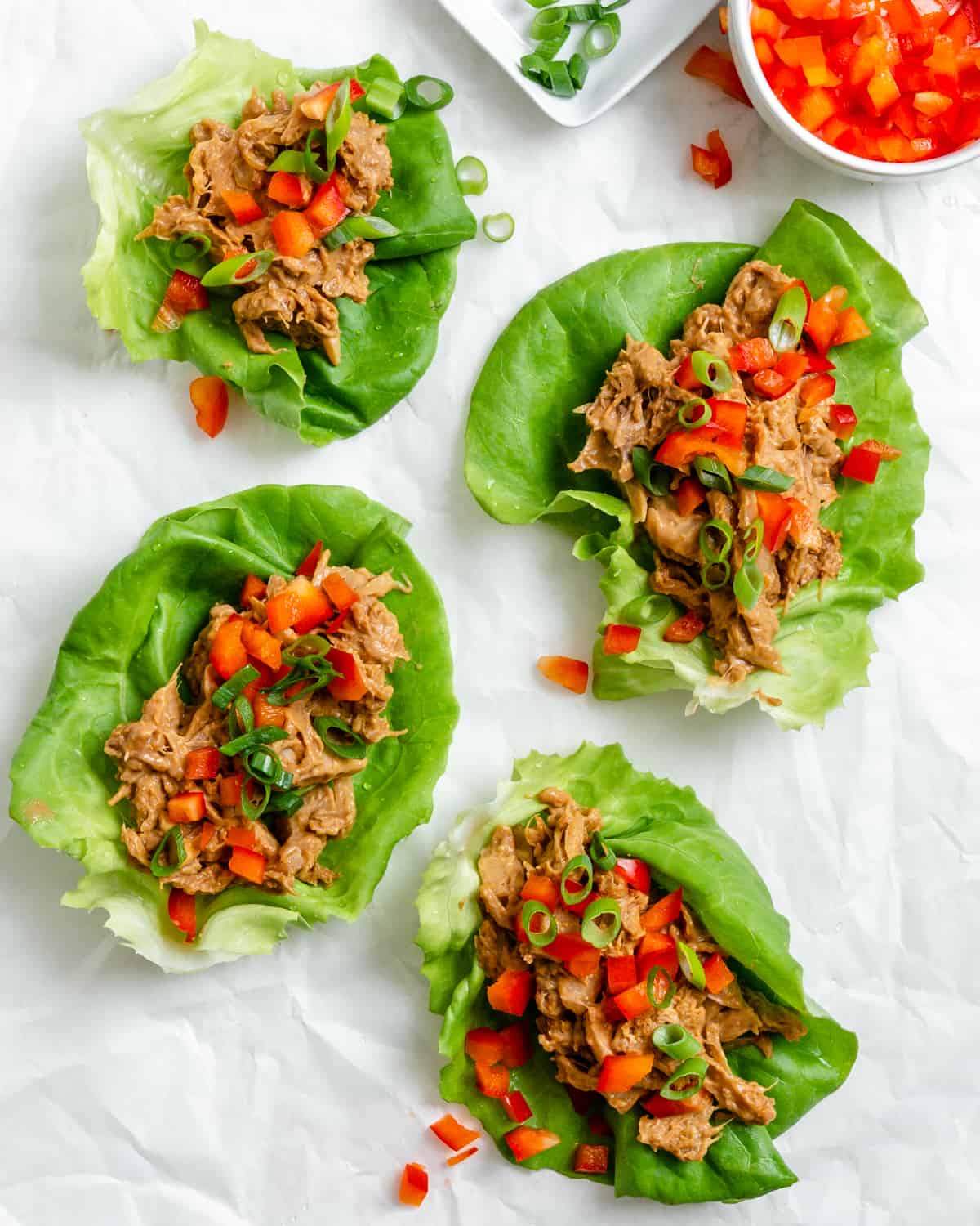 several completed Jackfruit Lettuce Cups spread out on a white surface