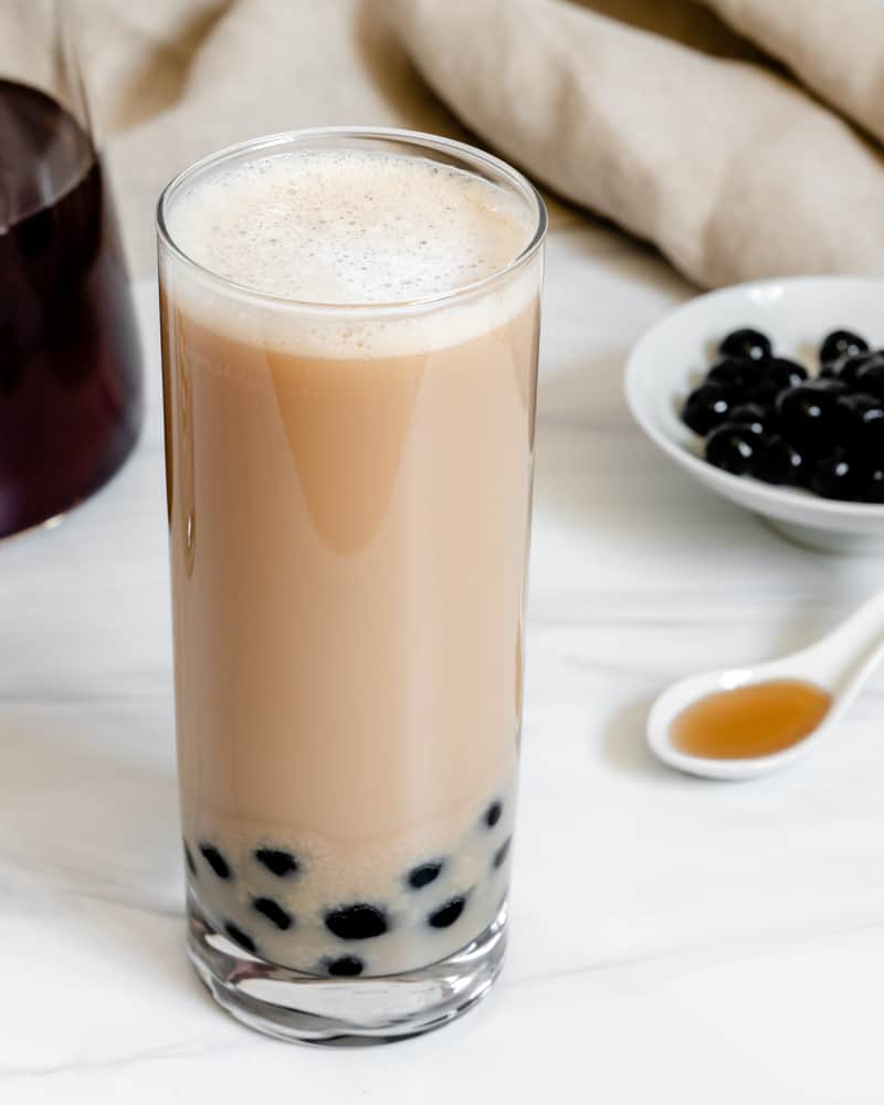 completed Easy Vegan Bubble Tea in a glass against a white background with ingredients