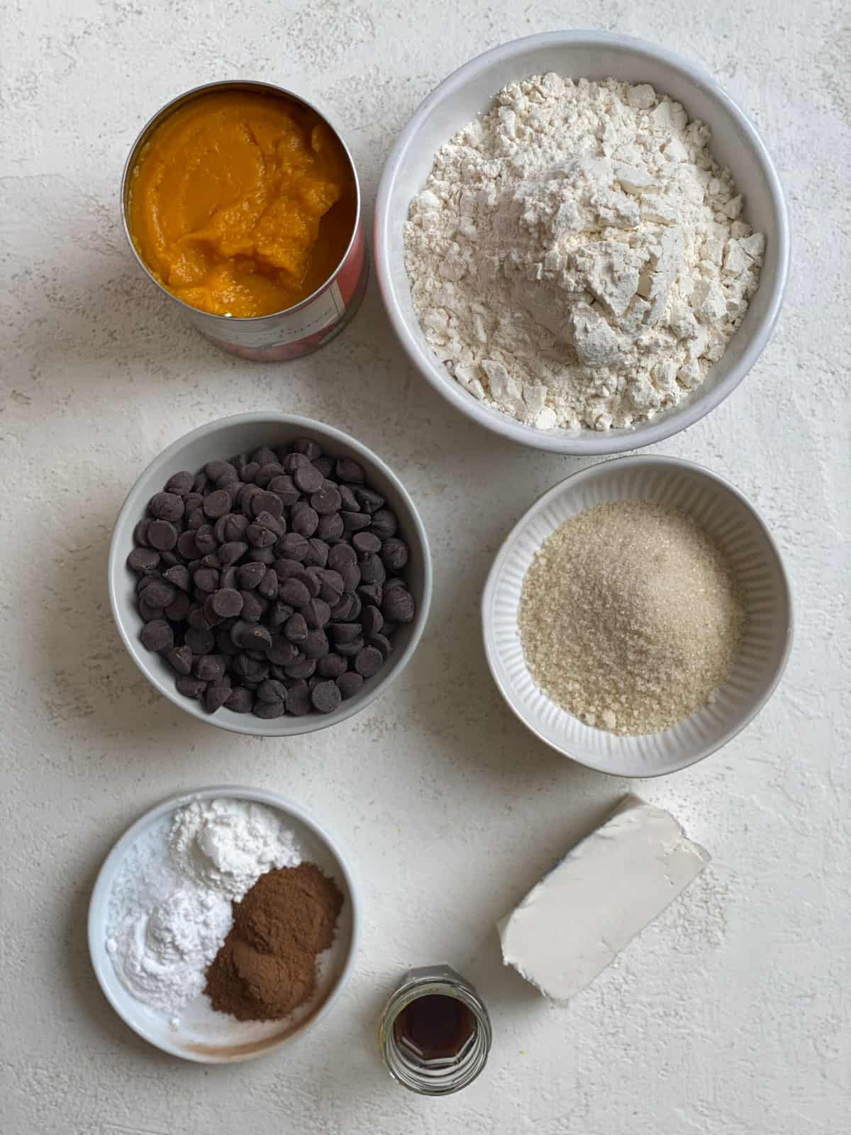 ingredients for Vegan Pumpkin Chocolate Chip Muffins measured out in individual white bowls